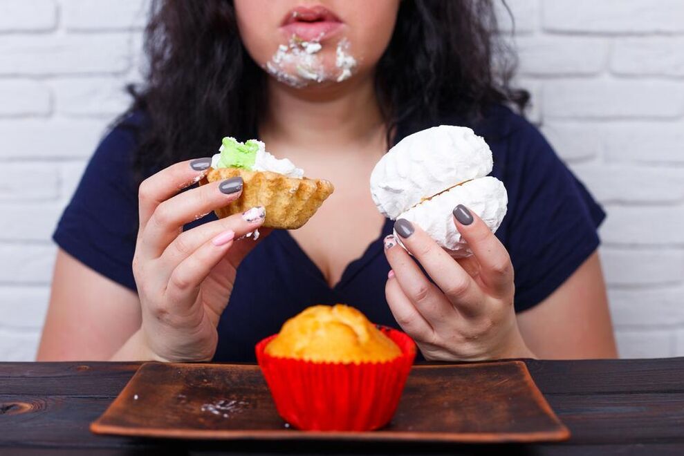 Толстая женщина ест сладости